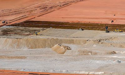 Stacking, irrigation, and leaching of ore at the leach pad